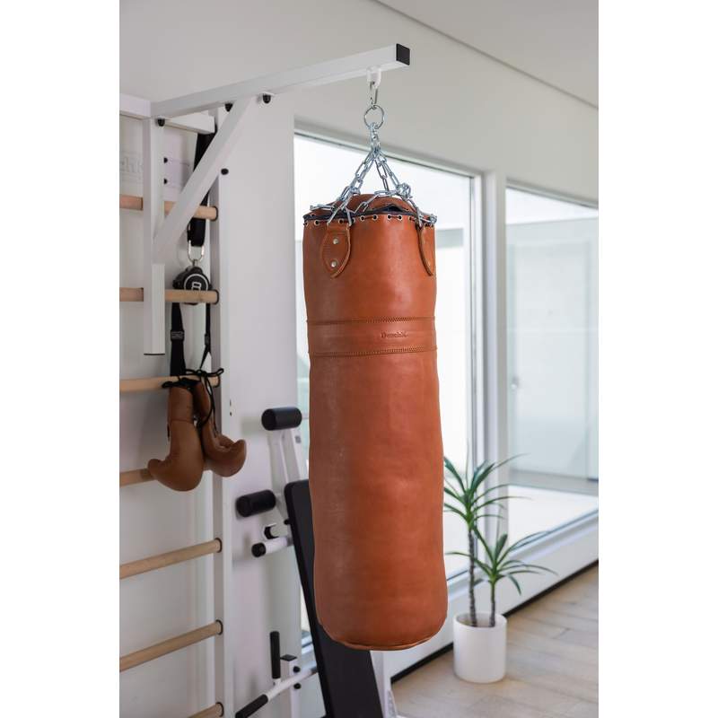 BenchK Leather Punching Bag – brown leather punching bag hanging from a wall bar setup
