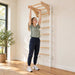 BenchK Wooden Pull-Up Bar PB204 – Teen doing a feet-supported overhead stretch with the light-beech wooden attachment; white wall bars shown are sold separately.