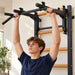 BenchK Convertible Pull-Up Bar PB3 – Close-up of a teen gripping the black pull-up attachment, with its removable rear hook frame visible; supporting wall bars are sold separately.