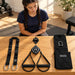 BenchK Recoil S2 Pro – Teen inspecting the trainer, two handles, lashing strap, carry bag/door mount and diamond-shaped permanent mount before training; background exercise equipment is sold separately.