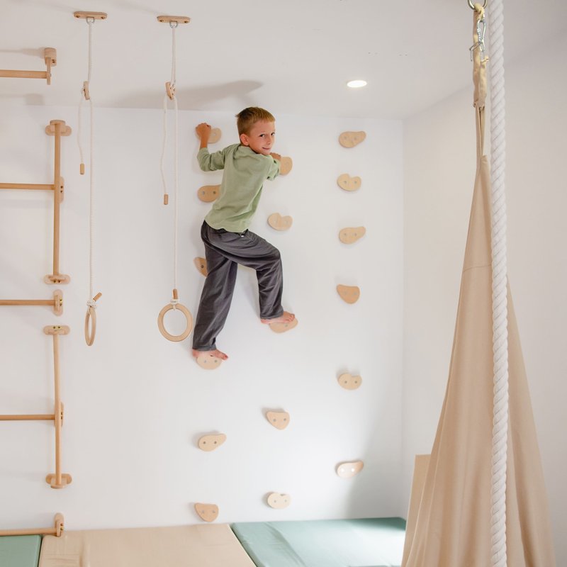 Climbing Holds – kid reaching between wall-mounted holds