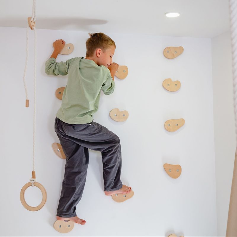 Climbing Holds – kid stepping between wooden climbing holds
