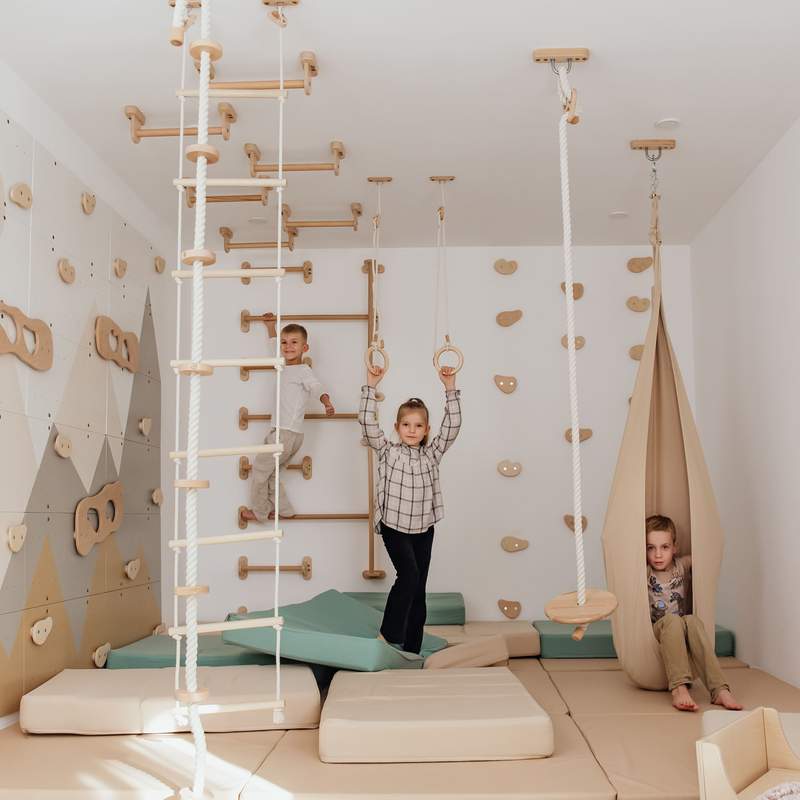 Wood and Hearts Climbing Wall Playground – kids using the rope seat and wall bars