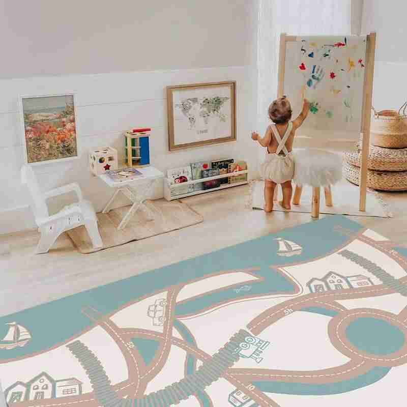 Baby drawing beside the Dakota Ivory Shwally Playmat in a family room