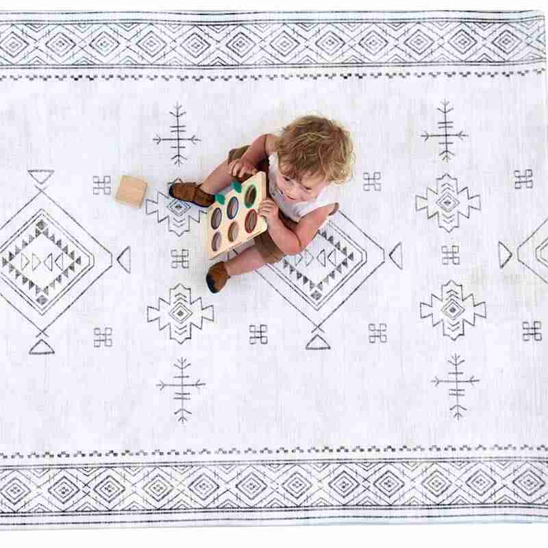 Baby lying on the cushioned Dakota Ivory Shwally Playmat viewed from above