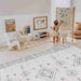 Kid painting beside the Dakota Ivory Shwally Playmat in a play space