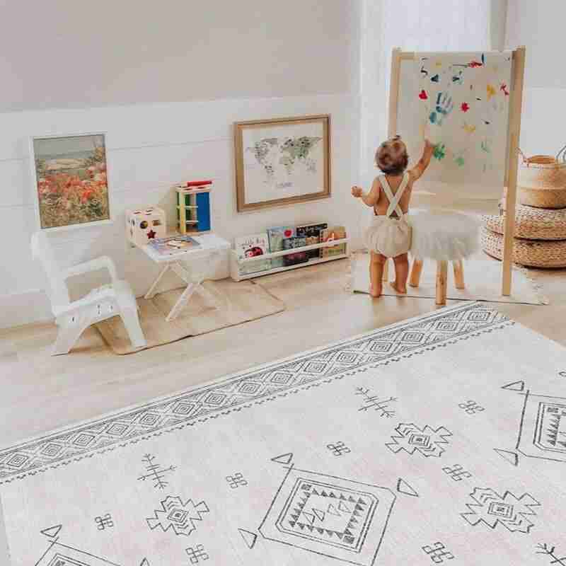 Kid painting beside the Dakota Ivory Shwally Playmat in a play space
