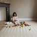 eeveve lucio desert sand double sided playmat with a girl playing with blocks