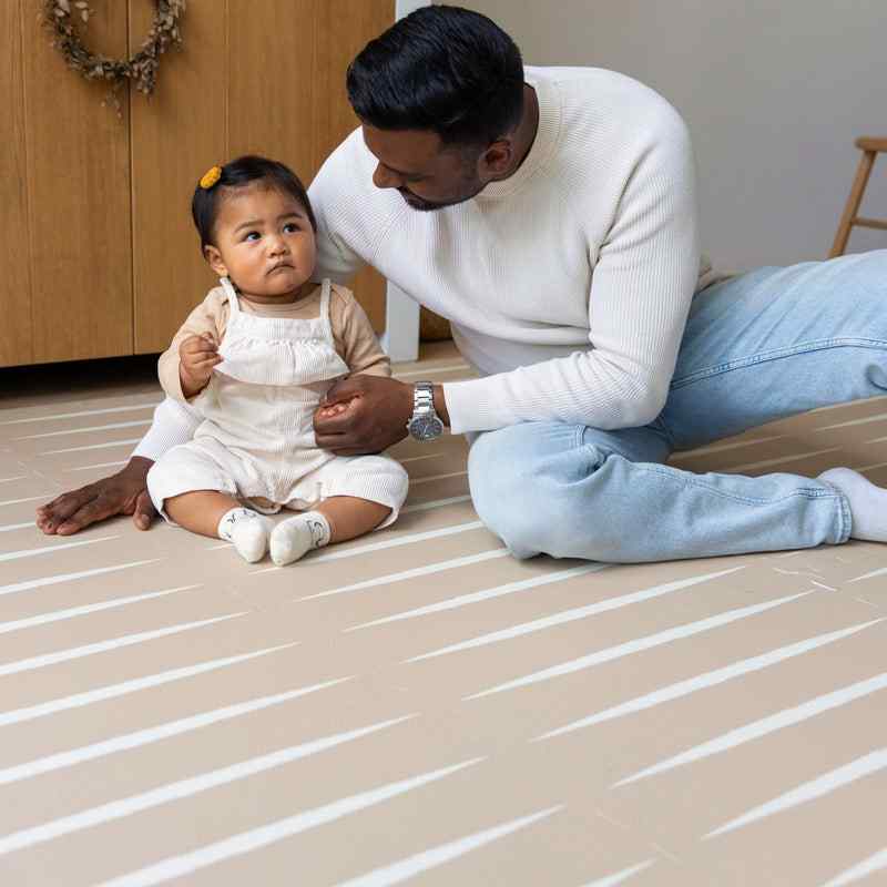 eeveve lucio desert sand double sided playmant with a toddler