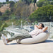 Outdoor Moon Pod – adult reclining on a covered Moon Pod on a patio
