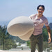 Outdoor Moon Pod – adult carrying the covered Moon Pod over one shoulder