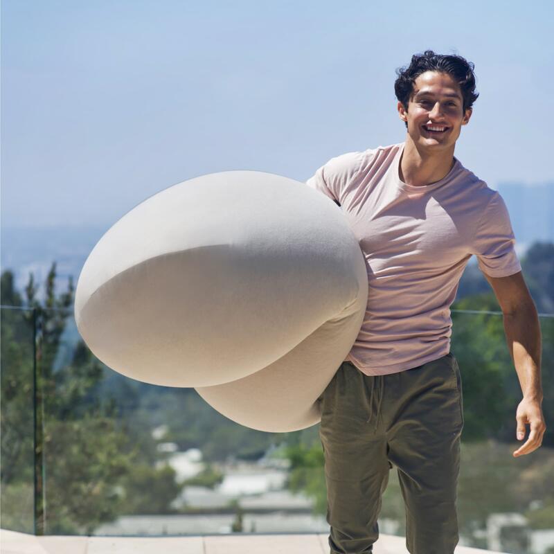 Outdoor Moon Pod – adult carrying the covered Moon Pod over one shoulder