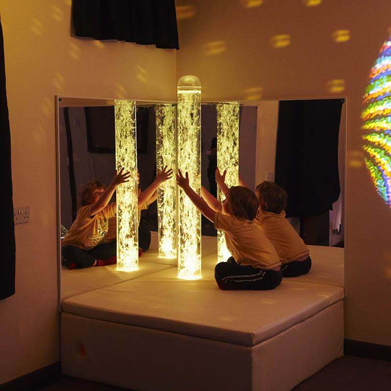 Children using the Experia Interactive LED Bubble Tube Corner glowing yellow
