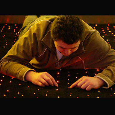 Child lying on the Experia LED Fiber Optic Carpet
