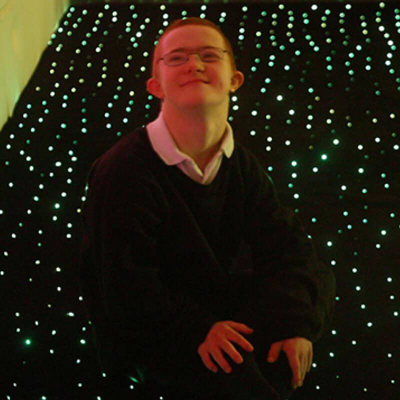 Child sitting on the Experia LED Fiber Optic Carpet