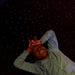 Top view of a child lying on the Experia LED Fiber Optic Carpet