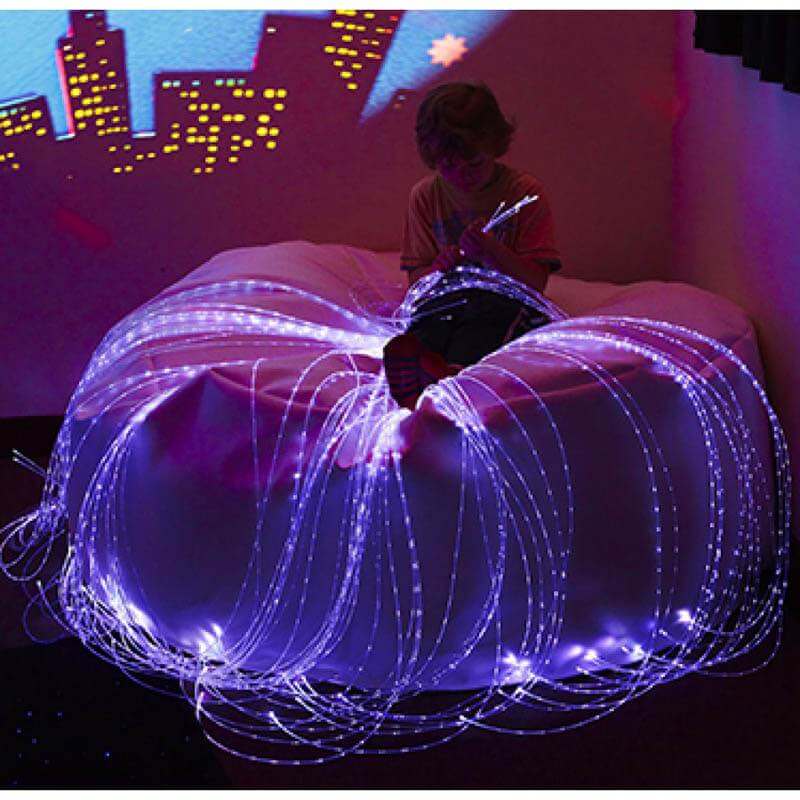 Child seated on Experia LED Fiber Optic Light Strands with Softie Bean Bag