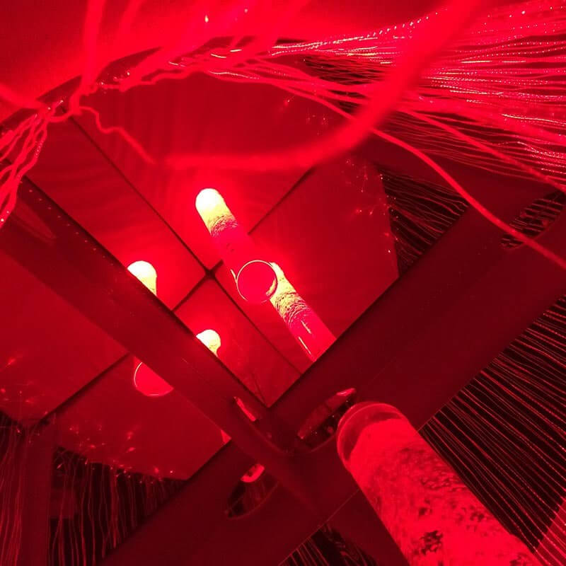 Inside view of Experia Sensory Cocoon with red illuminated bubble tube and fiber optics