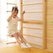 Girl Happily Swings on a Swing in the Avenlur 9-in-1 Indoor Playground Room