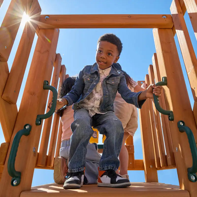 Gorilla Playsets Summerville Deluxe Swing Set – child at the clubhouse entrance with safety handles