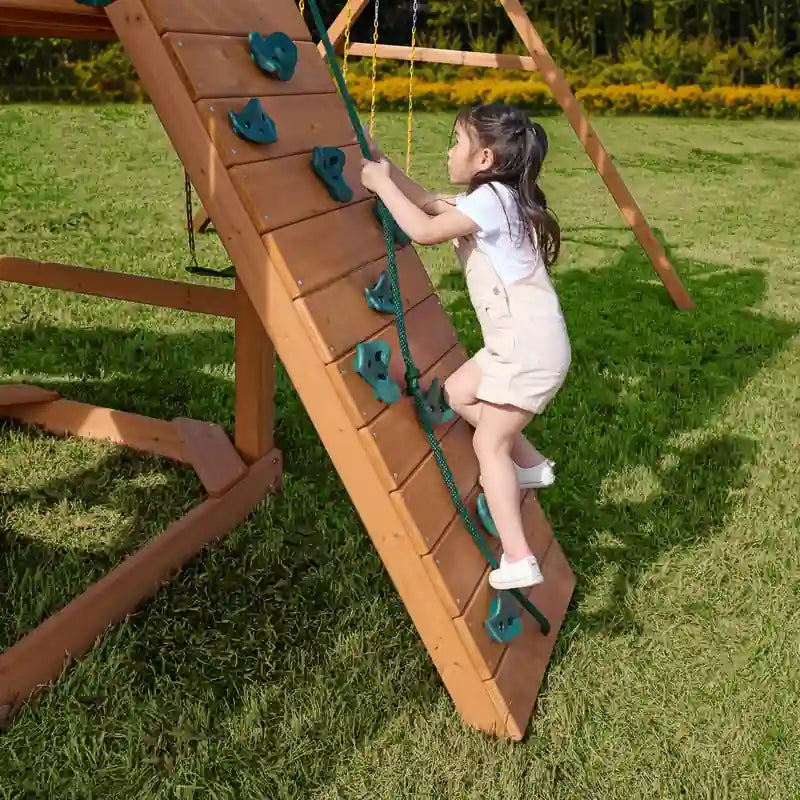 Gorilla Playsets Summerville Deluxe Swing Set – child climbing the rock wall