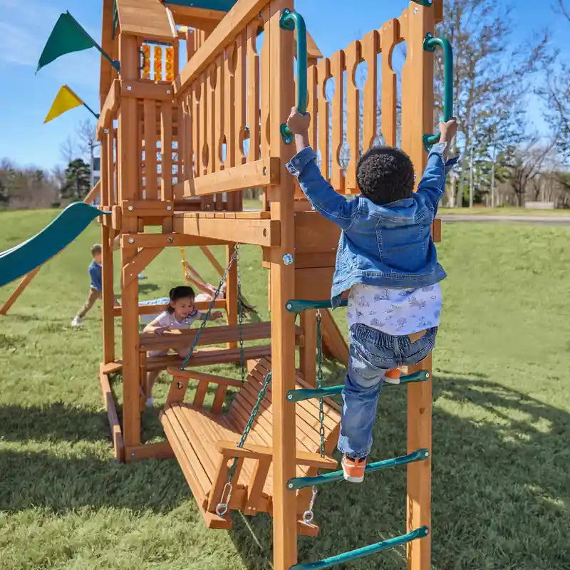 Gorilla Playsets Summerville Deluxe Swing Set – child climbing the vertical ladder beside the bench swing