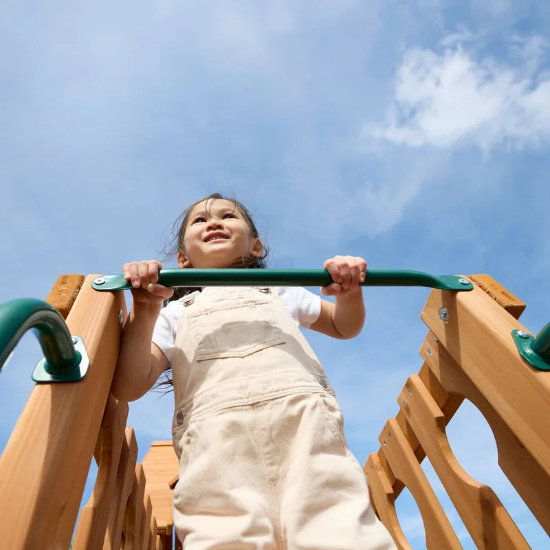 Gorilla Playsets Summerville Deluxe Swing Set – child holding the horizontal climbing bar