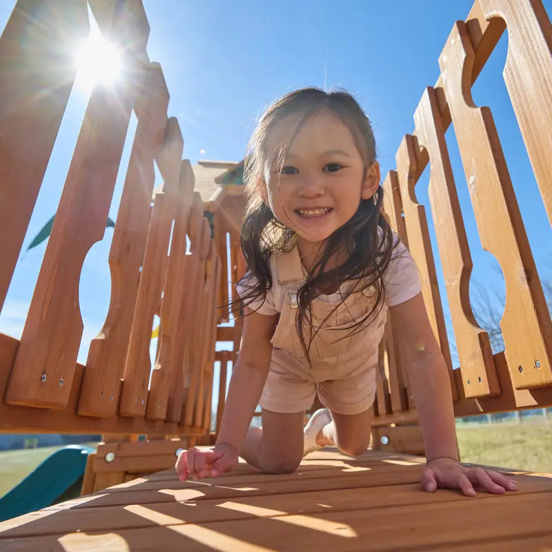 Gorilla Playsets Summerville Deluxe Swing Set – child on the upper wooden play deck