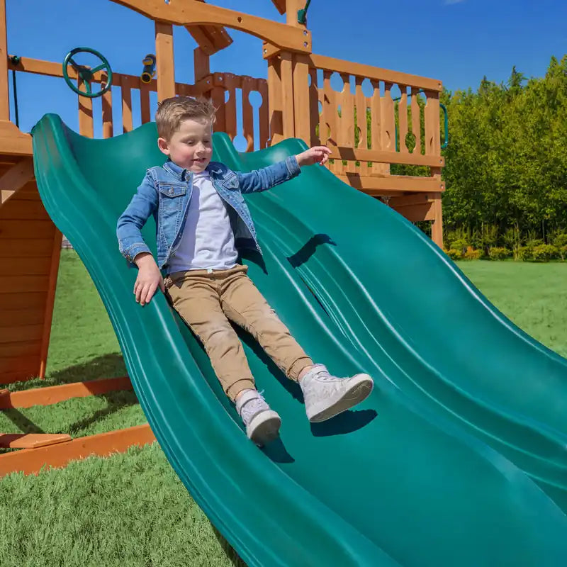 Gorilla Playsets Summerville Deluxe Swing Set – child riding an Alpine Wave Slide
