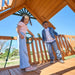 Gorilla Playsets Summerville Deluxe Swing Set – children playing beneath the wooden clubhouse roof
