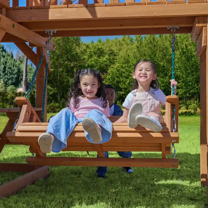 Gorilla Playsets Summerville Deluxe Swing Set – children sitting on the wooden bench swing