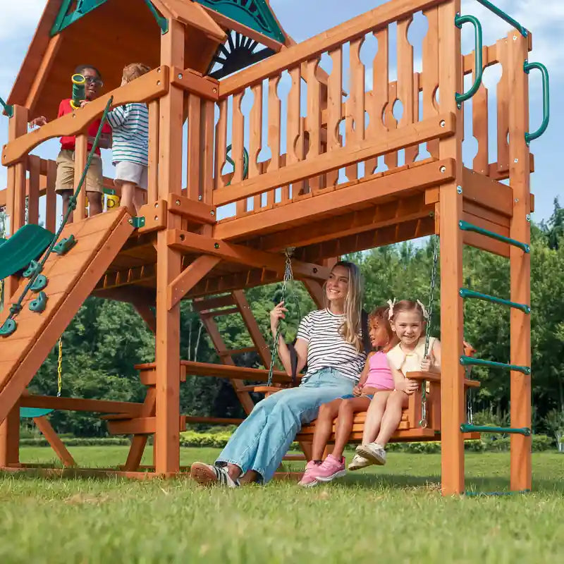 Gorilla Playsets Summerville Swing Set – family using the bench swing and upper clubhouse