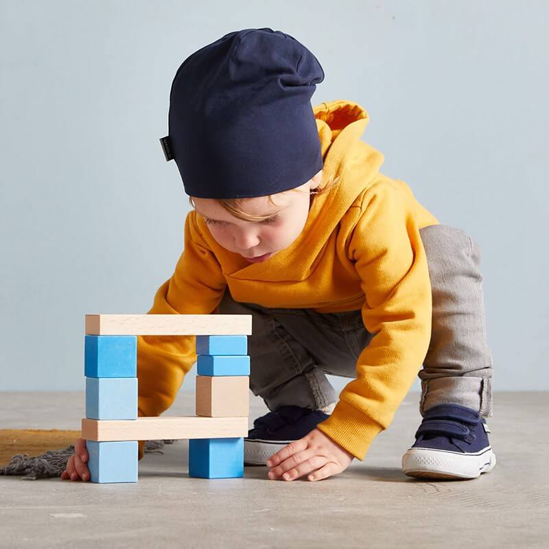 HABA Colored Wooden Building Blocks - 46 Piece Set – child creating a wooden block structure