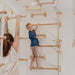 Home Monkey Bars – kid climbing long bars with an adult nearby