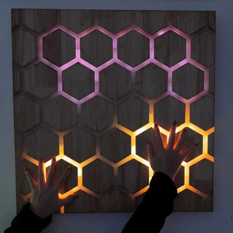 Honeycomb Touch Interactive Panel - hands touching yellow and pink light patterns