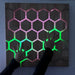 Honeycomb Touch Interactive Panel - hands following green and purple light patterns
