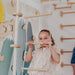 Kids Climbing Ropes – kid gripping a wooden rope ladder rung