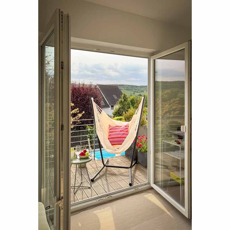Fiji Organic Latte – Organic Cotton Comfort Size Hammock Chair with Galvanized Steel Stand – Latte hammock chair with a striped cushion on a balcony