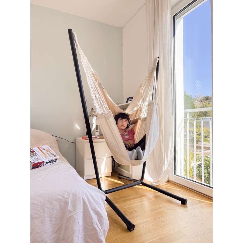 Fiji Organic Latte – Organic Cotton Comfort Size Hammock Chair with Galvanized Steel Stand – teen sitting with feet up in the Latte chair beside a bedroom window