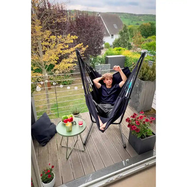 Fiji Organic Onyx – Organic Cotton Comfort Size Hammock Chair with Galvanized Steel Stand – person resting on a balcony