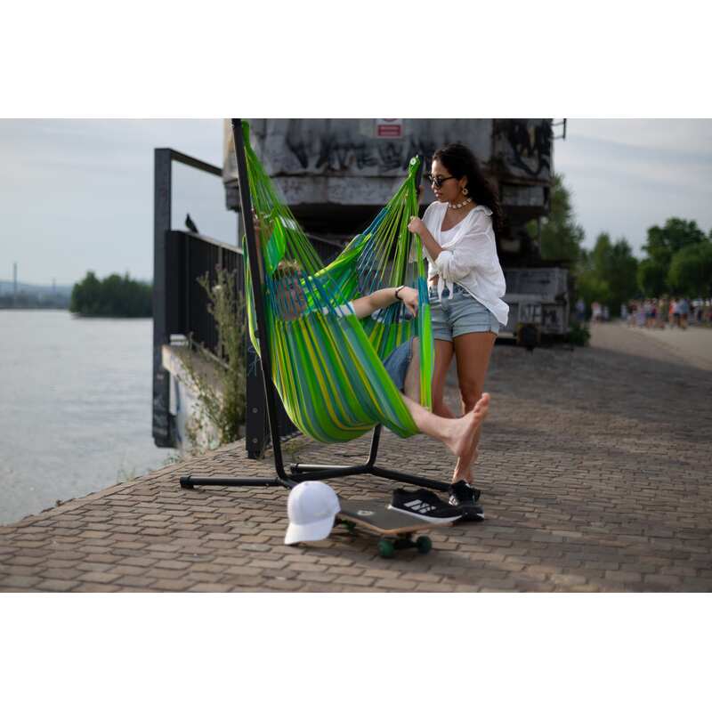 Fiji Outdoor Lime – Weather-Resistant Comfort Size Hammock Chair with Galvanized Steel Stand – person seated beside a waterfront