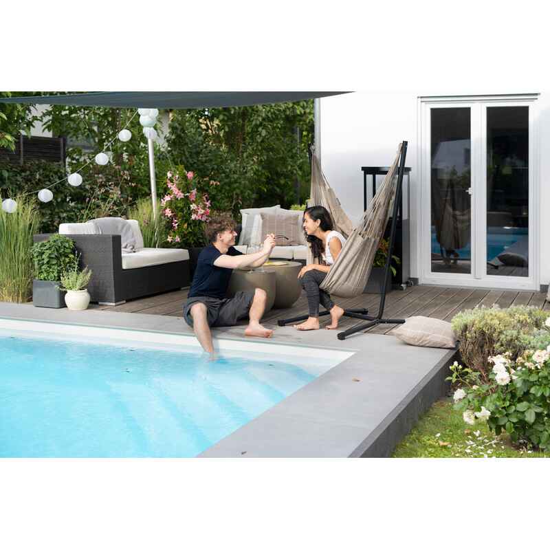 Fiji Outdoor Almond – Weather-Resistant Comfort Size Hammock Chair with Galvanized Steel Stand – person seated on a poolside patio