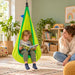 LA SIESTA Joki Froggy Kids Hanging Nest – lifestyle illustration of kid reading in the hanging nest with an adult nearby