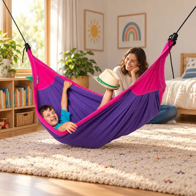 LA SIESTA Moki Lilly Kids Hammock with Suspension – lifestyle illustration of kid relaxing in a family reading corner with an adult nearby