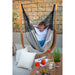 Udine Organic Zebra - Organic Cotton Hammock Chair with FSC® certified Eucalyptus Stand – person seated against a stone wall