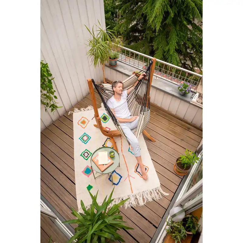 Udine Organic Zebra - Organic Cotton Hammock Chair with FSC® certified Eucalyptus Stand – person seated on a balcony