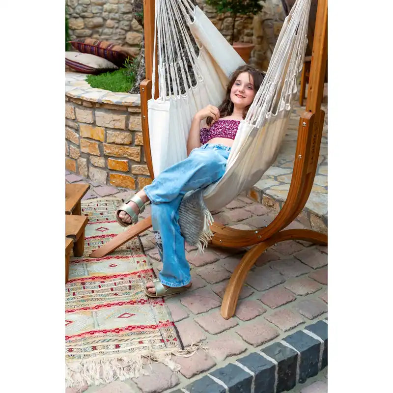 Udine Organic Latte - Organic Cotton Hammock Chair with FSC® certified Eucalyptus Stand – person reading in a brick courtyard