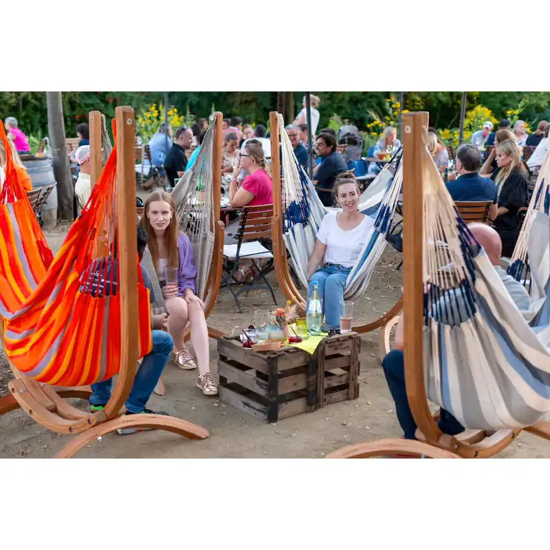 Udine Outdoor Almond - Weather-Resistant Hammock Chair with FSC® certified Eucalyptus Stand – people seated in colorful outdoor chairs