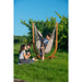 Udine Outdoor Almond - Weather-Resistant Hammock Chair with FSC® certified Eucalyptus Stand – seated person with a companion on the grass