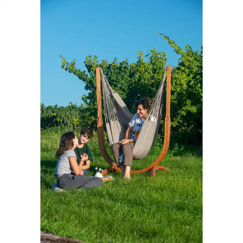 Udine Outdoor Almond - Weather-Resistant Hammock Chair with FSC® certified Eucalyptus Stand – seated person with a companion on the grass